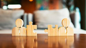 zu sehen sind zwei Puzzelteile aus Holz, die zusammenpassen aber noch nicht zusammengesteckt sind