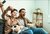 Foto von jubelndem Vater und Sohn auf dem Sofa mit Popcorn und Fußball